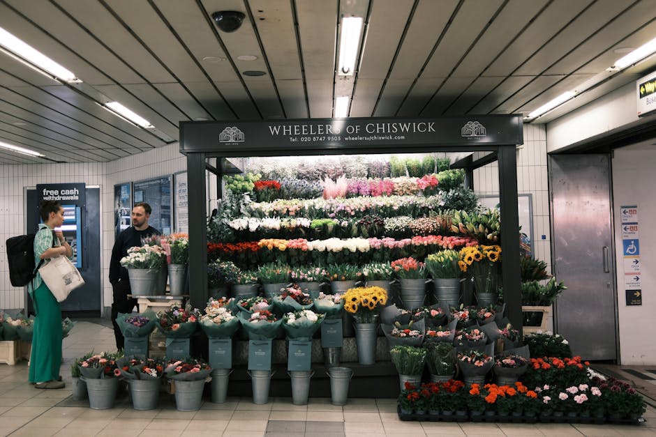 A vibrant floral display at Wheeler of Chiswick, situated in an underground station, featuring a variety of fresh flowers arranged in colorful bouquets and floral arrangements. The display includes su